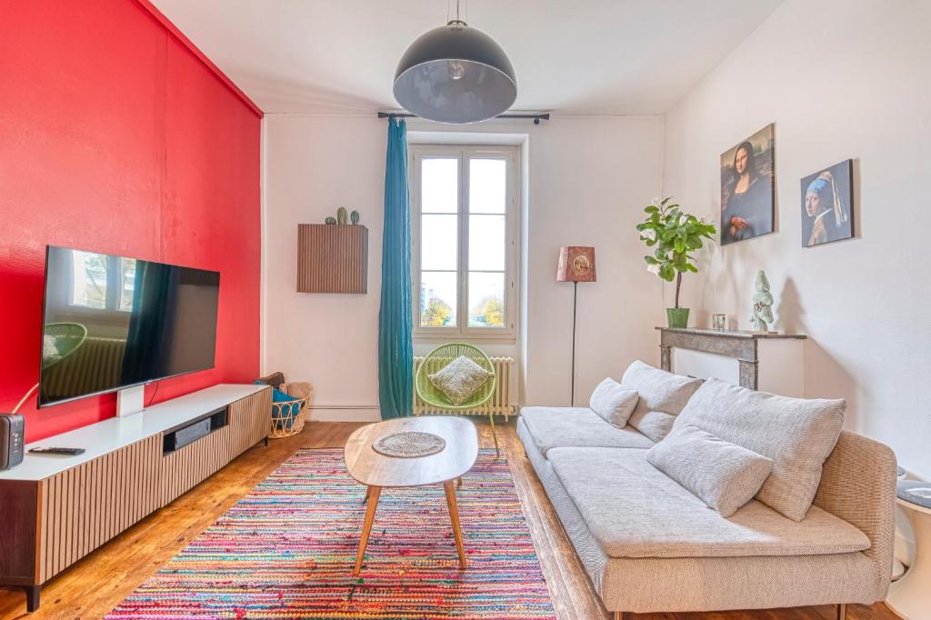 a living room with a couch and a tv at Le Nid Carnot - Cocon T4 au Cœur de la Ville in Angers