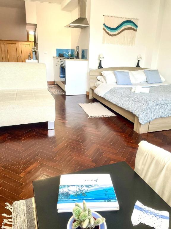 a living room with two beds and a table at Cozy Carcavelos Beach-NOVA SBE in Carcavelos
