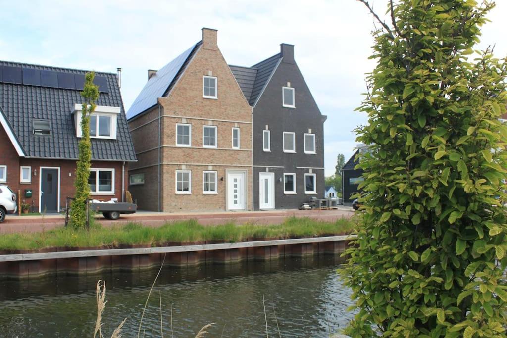 a group of houses next to a river at Wonderful house on water with 5 bedrooms and bathrooms in Stavoren