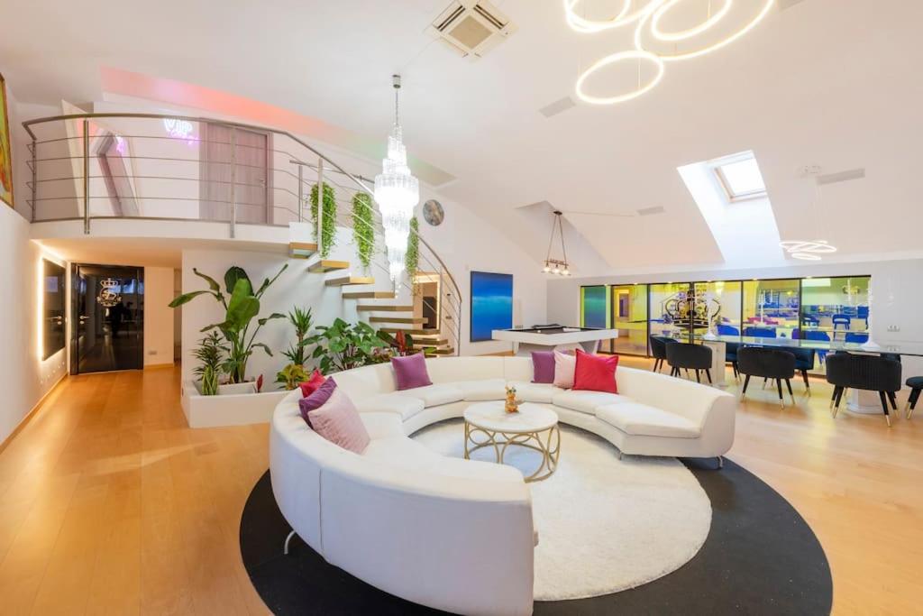 Una sala de estar con un sofá blanco y una escalera de caracol. en Piscina Interna Privata e Spa a Milano, en Milán