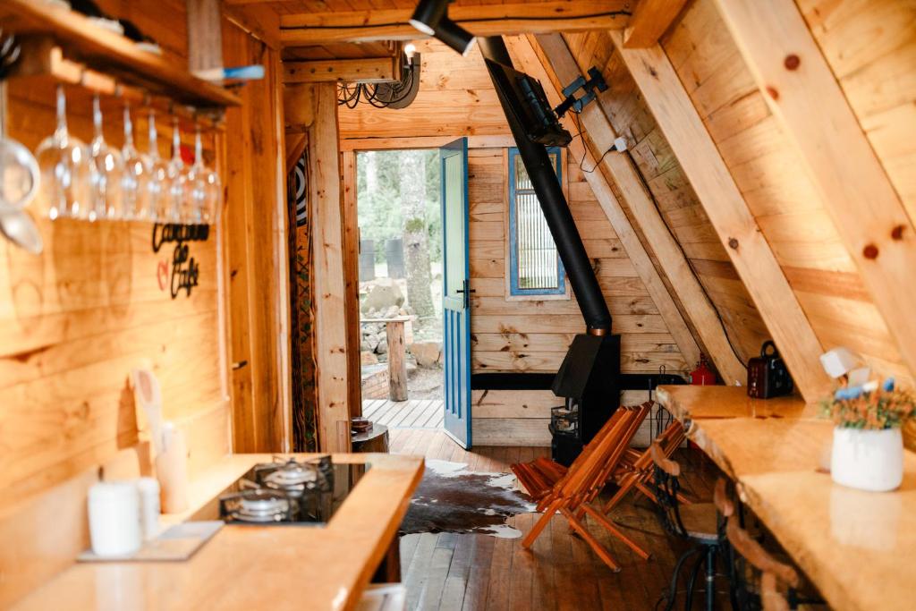 a view of a kitchen in a log cabin at Chalés Recanto do Vale - GRALHA AZUL in Bom Jardim da Serra