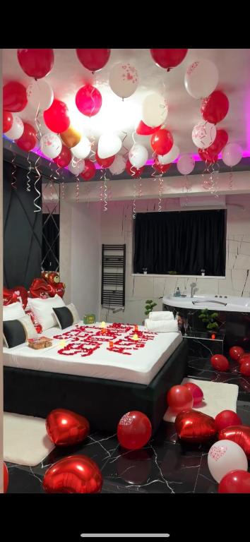 a room with a bed with red and white balloons at Relax Regim Apartament in Bucharest