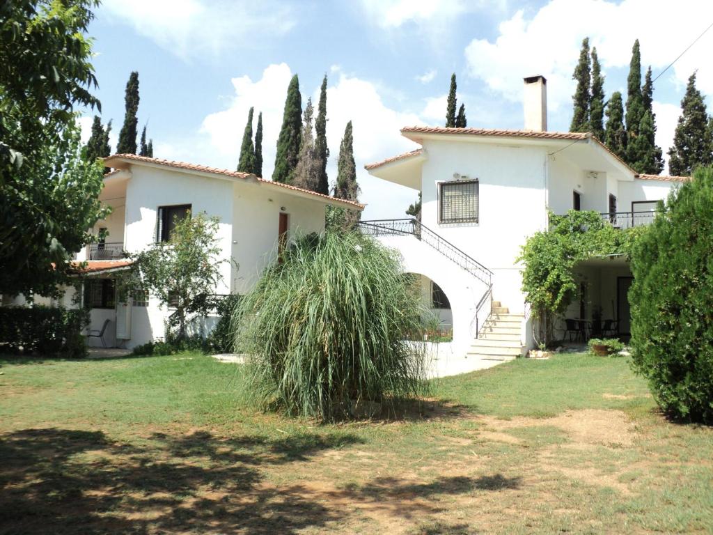 una gran casa blanca con un montón de árboles en Marietta's Apartments, en Agios Andreas - Mesenia