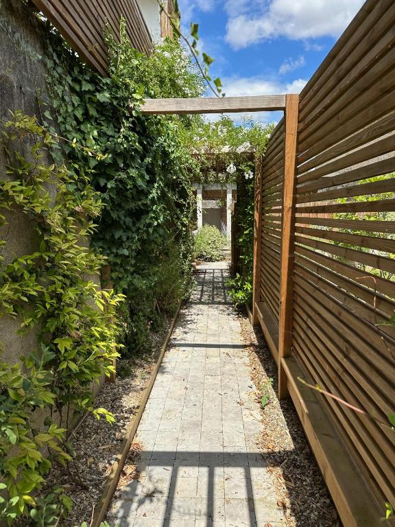 une passerelle traversant un jardin avec une clôture dans l'établissement Petit Bengale, à Talence