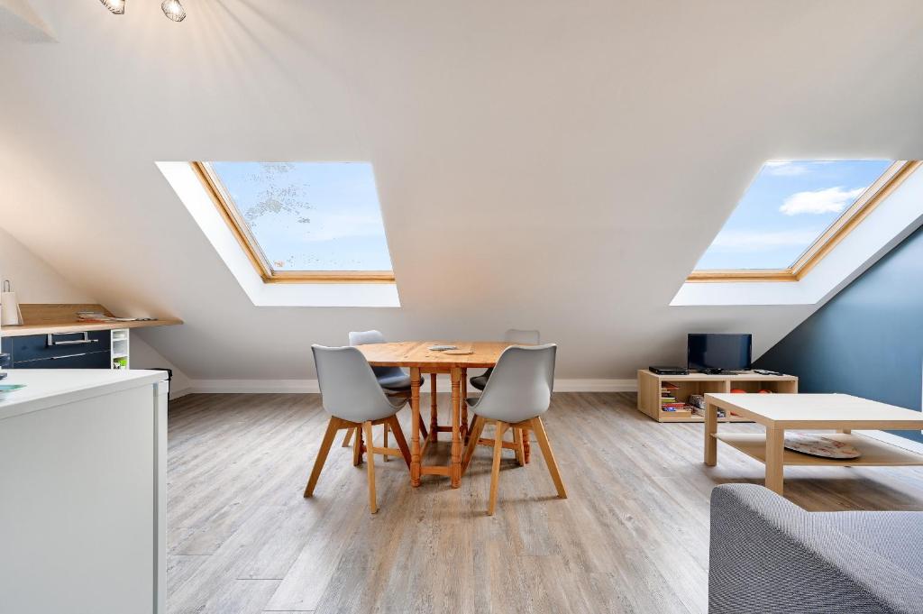 - une salle à manger avec une table et deux lucarnes dans l'établissement Hameau de la Belle Sayette, appartement pour 4, à Val Louron