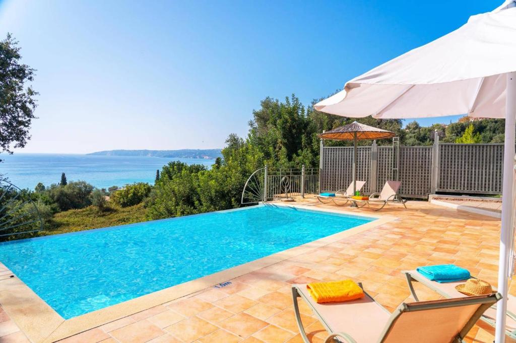 a swimming pool in a villa with a view of the ocean at Villa Andrea by Villa Plus in Lourdhata