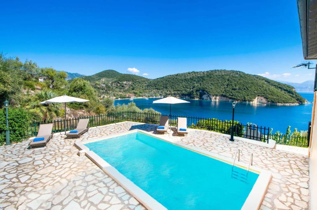 a swimming pool with a view of the water at Villa Votsalo Desimi by Villa Plus in Katokhórion