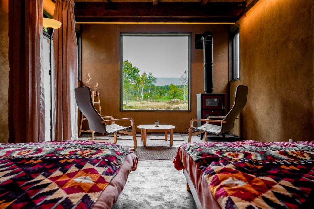 a bedroom with a bed and a table and a window at Kita Karuizawa Morino Takibi Dogs OK! in Tsumagoi