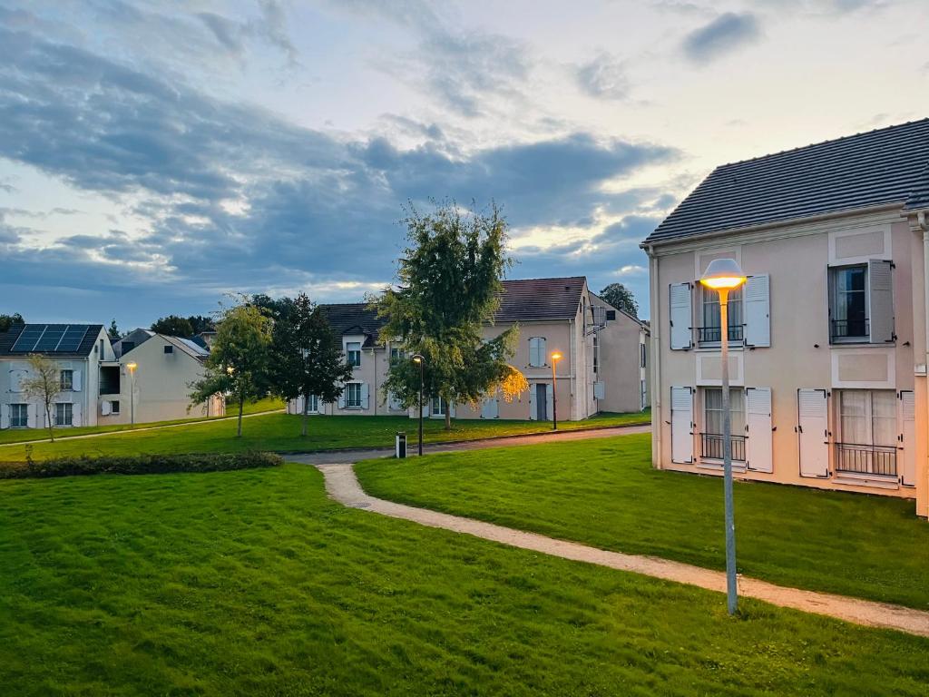 una casa con una farola en un patio en Appart Hôtel 3* dans une résidence de tourisme, en Le Mée-sur-Seine