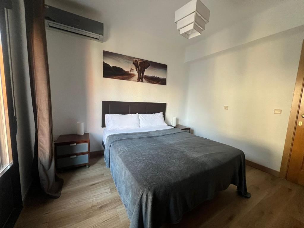 a bedroom with a bed and a painting on the wall at Hello Madrid in Madrid