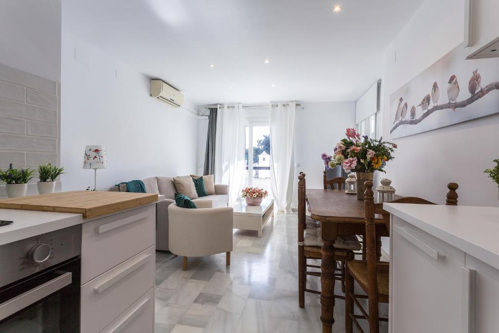 a kitchen and living room with a table and chairs at Vistahermosa Piscina Vistas in El Puerto de Santa María