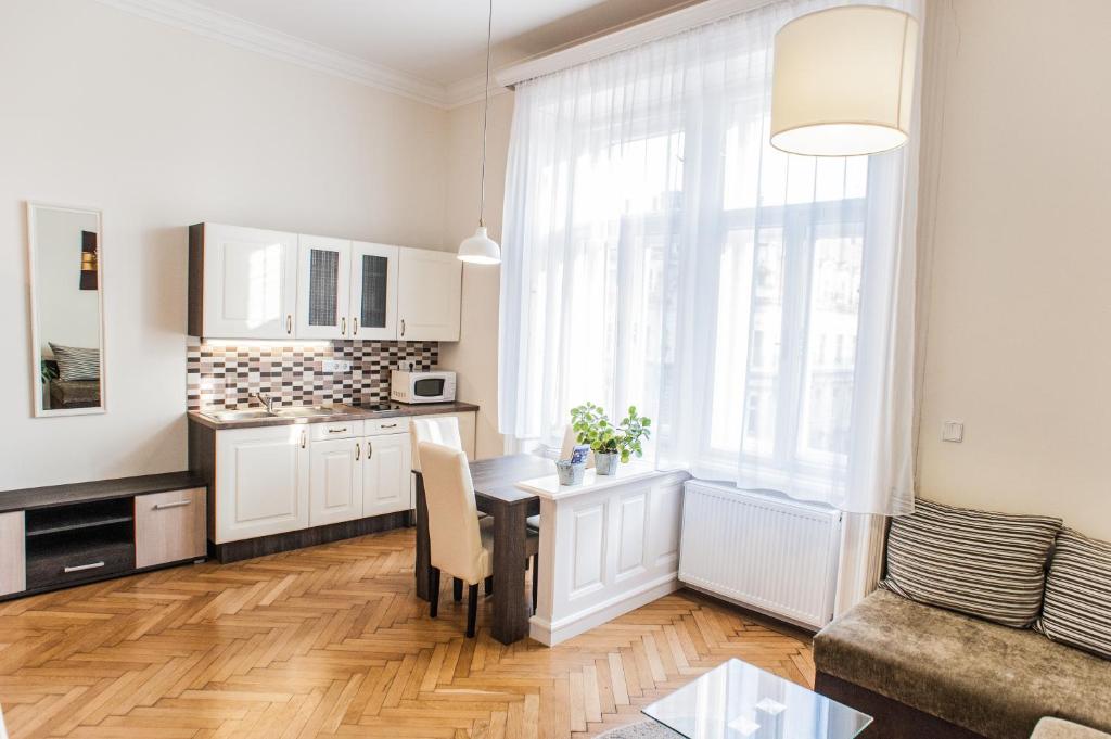 a kitchen and living room with a table and a window at All In Apartman in Budapest