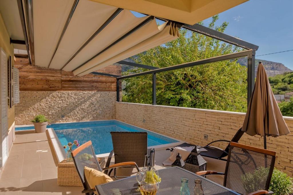 ŽrnovnicaにあるLuxury Villa LeLu with heated saltwater pool, parking, high speed Internet, BBQ,のパティオ(スイミングプール、パラソル付)