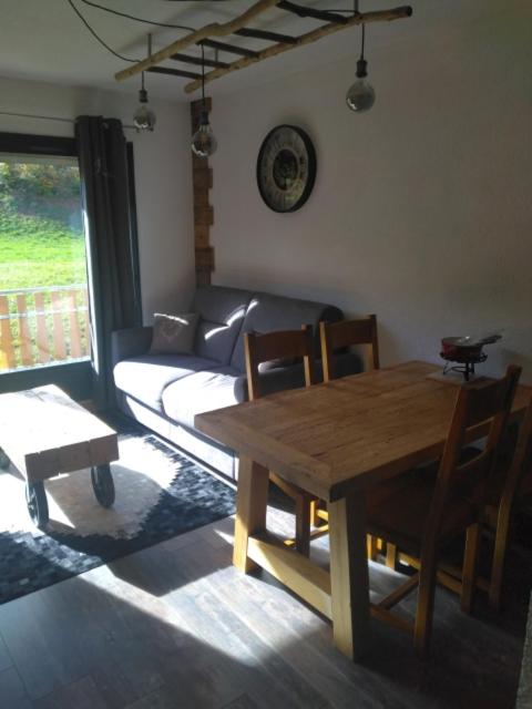un salon avec une table en bois et un canapé dans l'établissement Appartement montagne haut jura, à Bellefontaine