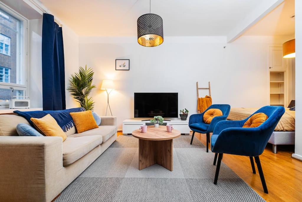 a living room with a couch and chairs and a tv at Prime City Escape 45 Square Meters in Helsinki