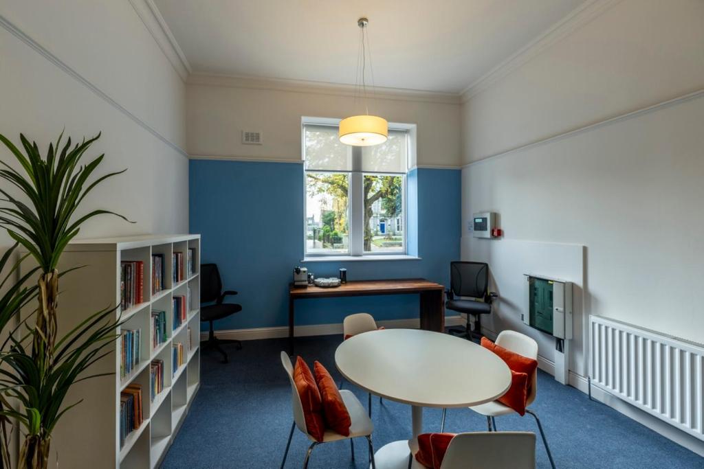 a room with a table and chairs and a window at 8QR Rooms in Aberdeen