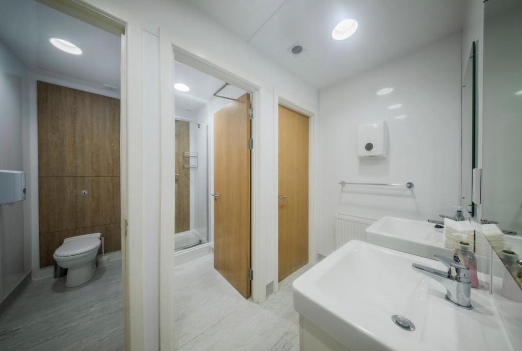 a white bathroom with a sink and a toilet at 8QR Rooms in Aberdeen