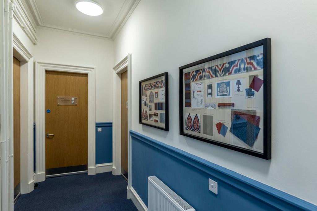 a hallway with two framed pictures on a wall at 8QR Rooms in Aberdeen
