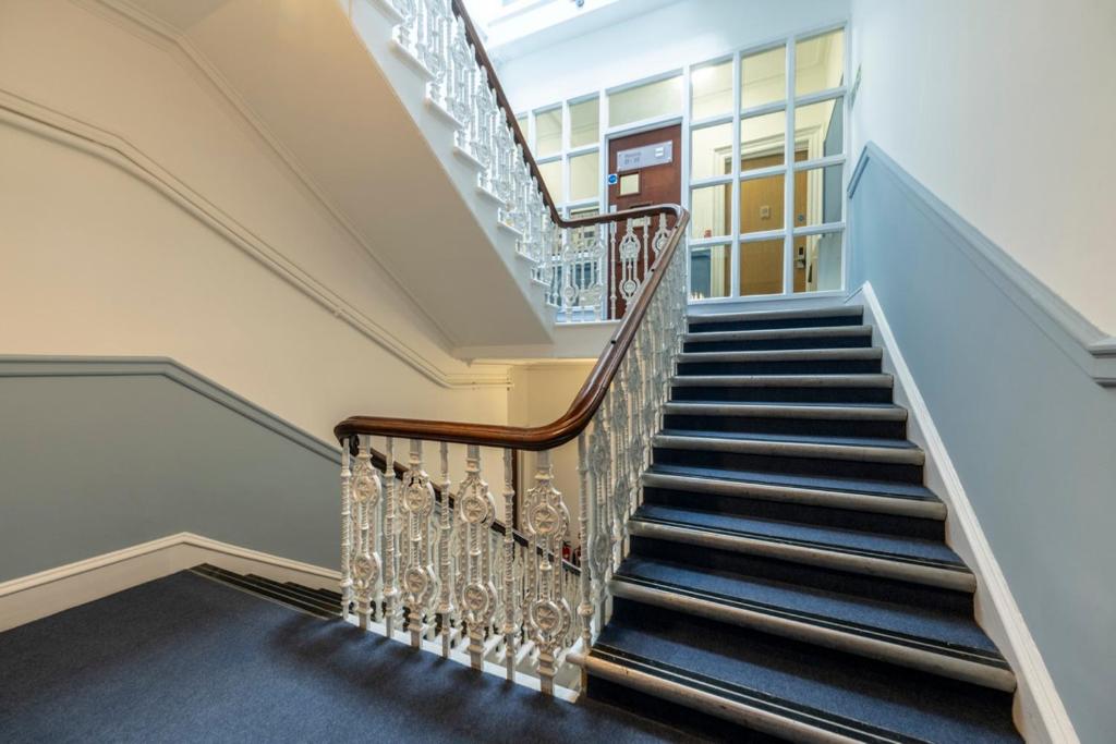 a staircase in a home with blue and white walls at 8QR Rooms in Aberdeen
