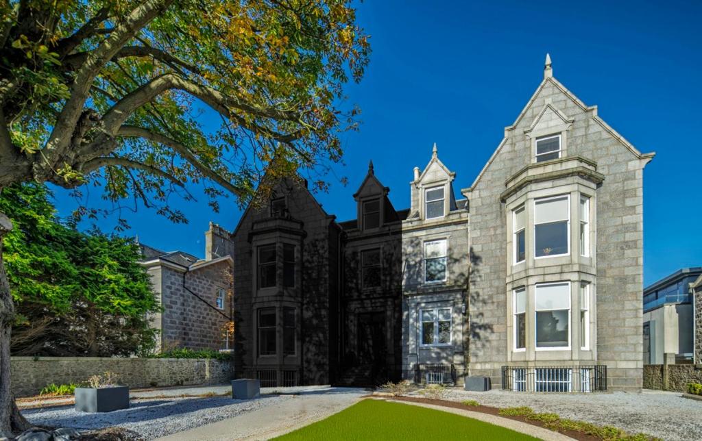 a large brick house with a green lawn in front of it at 8QR Rooms in Aberdeen