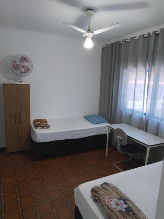 Una pequeña habitación con una cama y una ventana. en Hotel Pousada Liberdade, en Pindamonhangaba