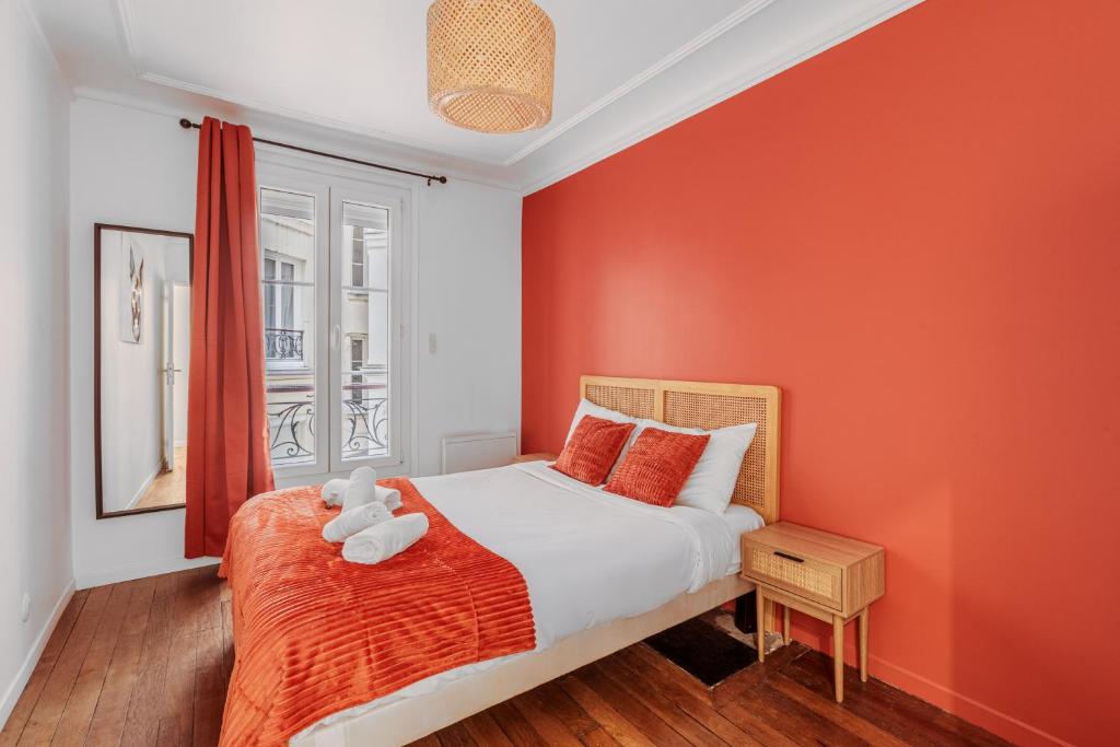 - une chambre avec des murs orange et un lit avec un ours en peluche dans l'établissement Splendide appartement Paris 18eme 6P, à Paris