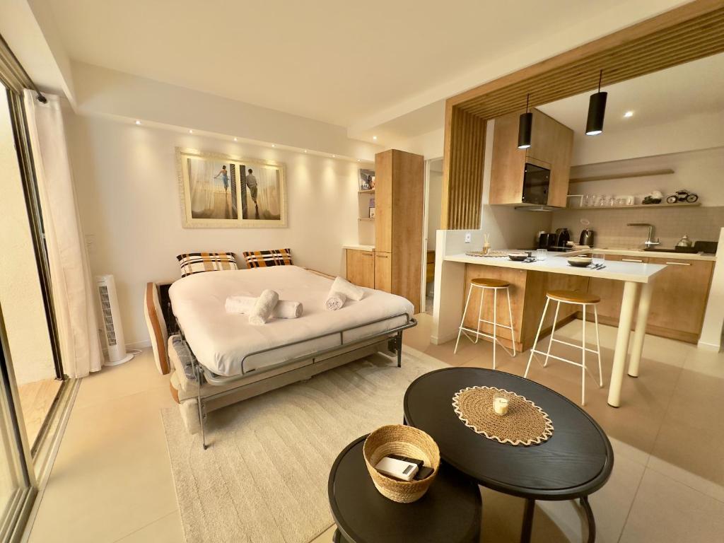 une grande chambre avec un lit et une cuisine dans l'établissement Évasion Bohème - Studio avec terrasse au cœur de Cannes, à Cannes