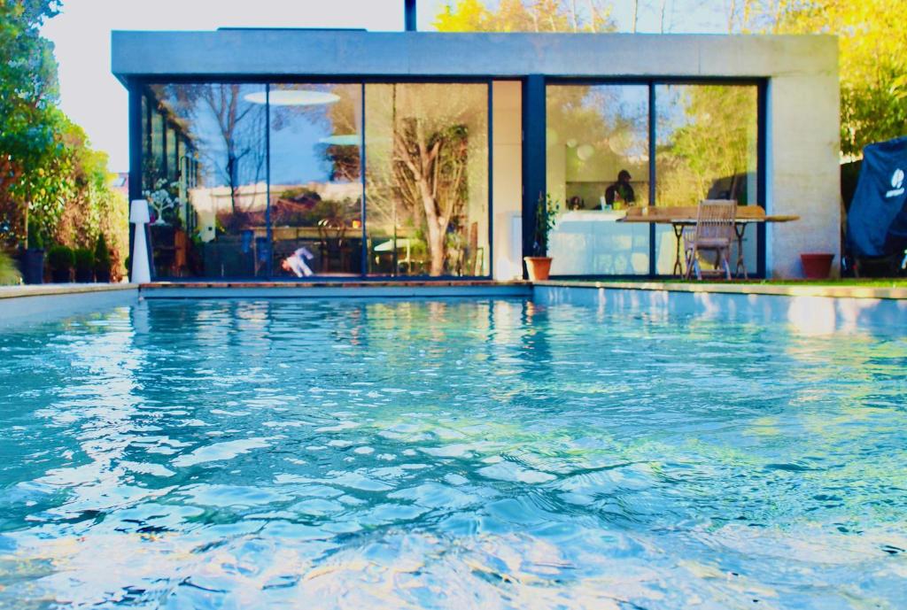 a swimming pool in front of a house at Oasis de Caudéran in Bordeaux