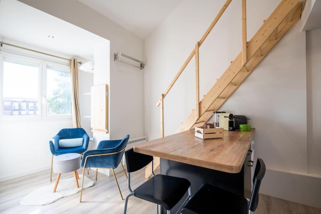 a room with a table and chairs and a staircase at Beau Studio Rénové - Lille JB Lebas in Lille