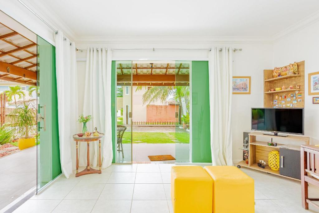グアラジュバにあるGB01 Excelente Casa 4 Suítes em Guarajuba com Piscina e Wi-fiのガラスの引き戸のあるリビングルーム
