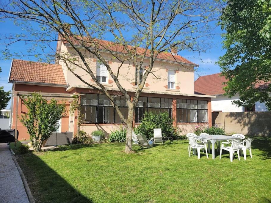 a table and chairs in front of a house at Casa Soma in Saint-Marcel