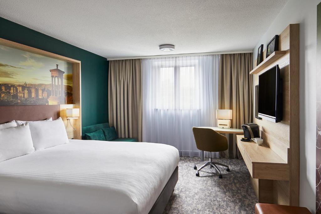 エディンバラにあるLeonardo Hotel Edinburgh Haymarketのベッドと机があるホテルの部屋