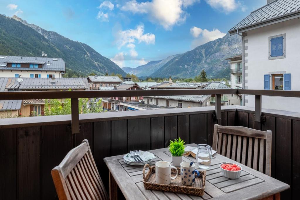 d'une table sur un balcon avec vue sur les montagnes. dans l'établissement Charming apartment with mountain view, à Chamonix-Mont-Blanc