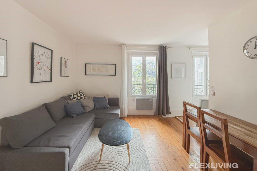 un salon avec un canapé et une table dans l'établissement Flexliving - One bedroom - Houdon, à Paris
