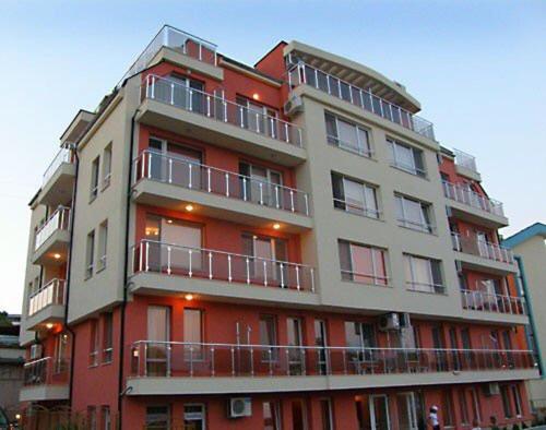 un alto edificio rosso con balconi in cima di Hotel Topalovi a Nesebar