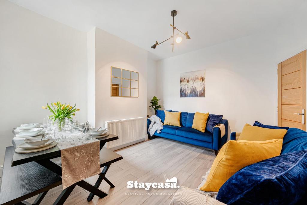 a living room with a blue couch and a table at Monton Co-living - Private Room Self-cater in Manchester