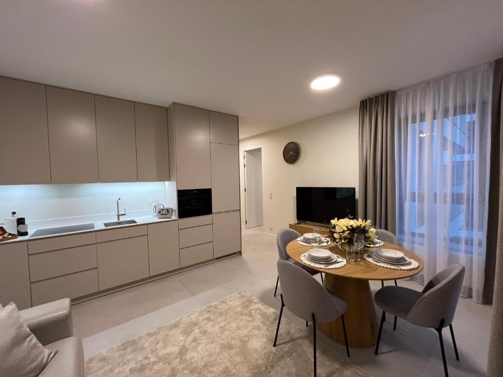 a kitchen and dining room with a table and chairs at TM APARTMENTS Ludwiki in Warsaw