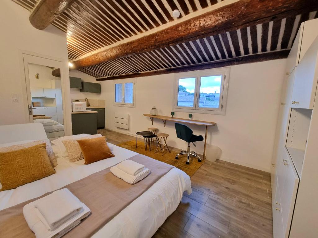 une chambre avec un grand lit et un bureau dans l'établissement Studio lumineux clim - centre ville, à Aix-en-Provence