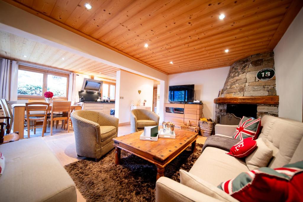 un soggiorno con un divano e un tavolo di Appartement de prestige dans chalet Novalsia à Méribel avec sauna a Méribel