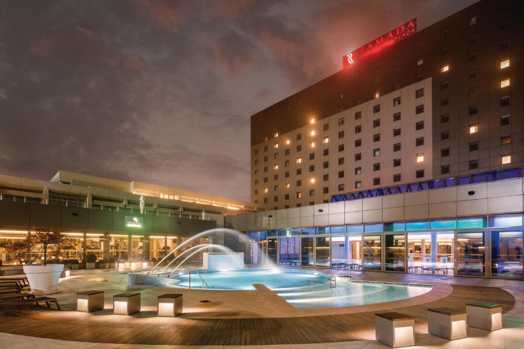 a hotel with a fountain in front of a building at Ramada Plaza by Wyndham Bucharest Convention Center in Bucharest