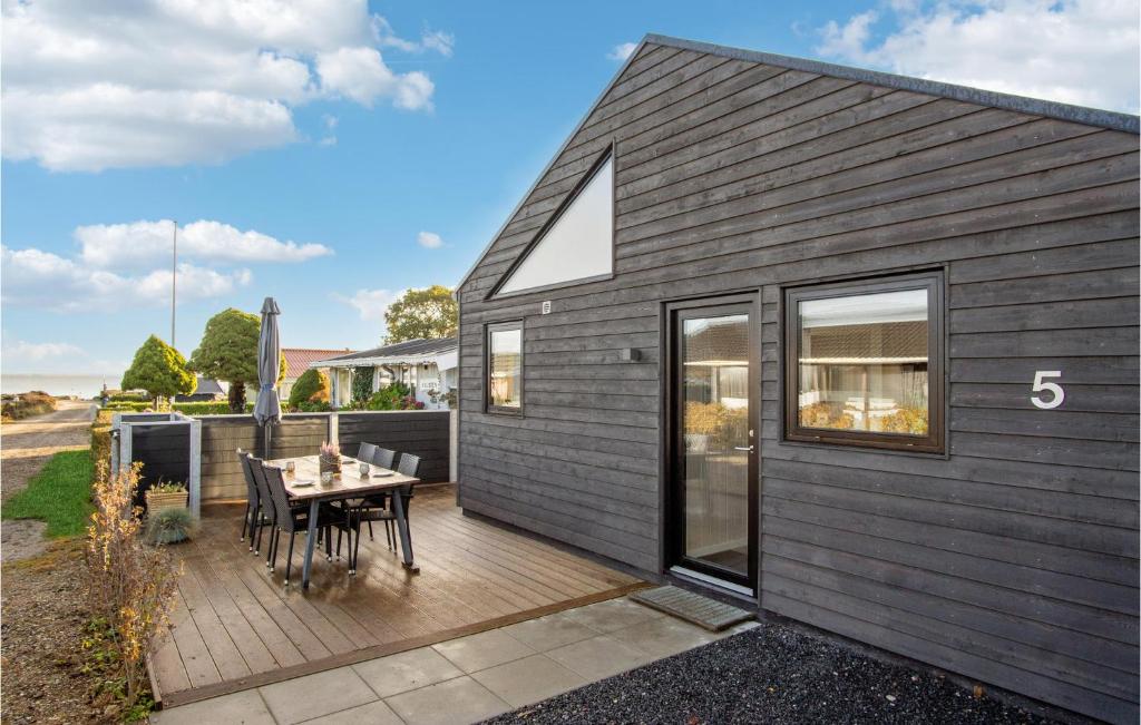 a small black house with a wooden deck at Lovely Home In Sjølund in Sjølund