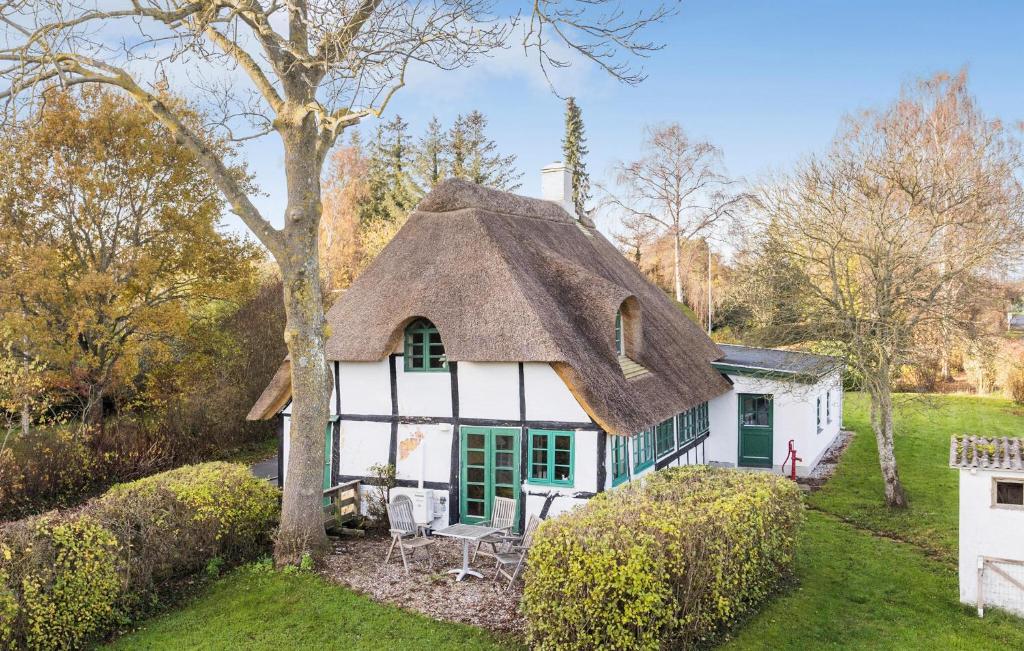 a cottage with a thatched roof in a yard at Three-Bedroom Holiday Home In Tranekar in Østerhuse