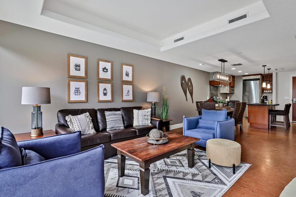 een woonkamer met een bank en blauwe stoelen bij Classic Hideaway Elegant 2BD 2BTH in Canmore