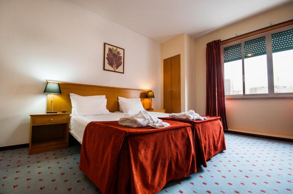 リスボンにあるResidencial do Areeiroのベッドと窓が備わるホテルルーム