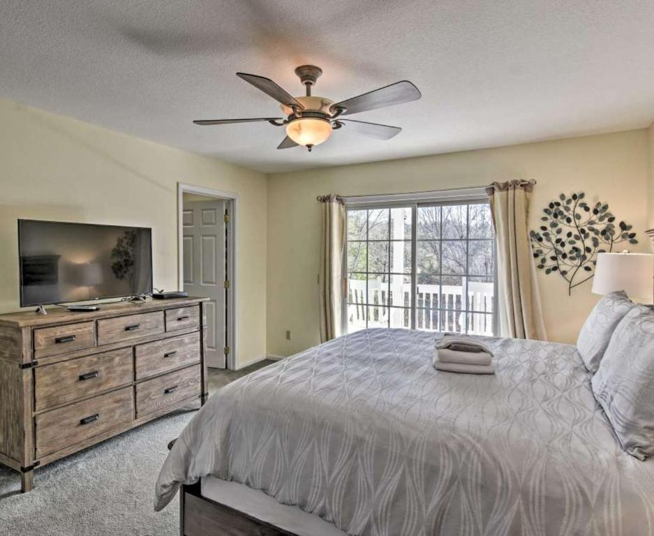 a bedroom with a bed with a ceiling fan and a television at Brook Knoll · NEW! Beautiful Mtn Retreat w/Pool Near Asheville! in Weaverville