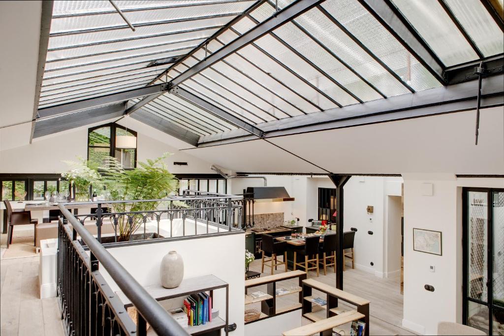 une cuisine ouverte et une salle à manger avec un plafond en verre dans l'établissement Paris Green House residence, à Paris