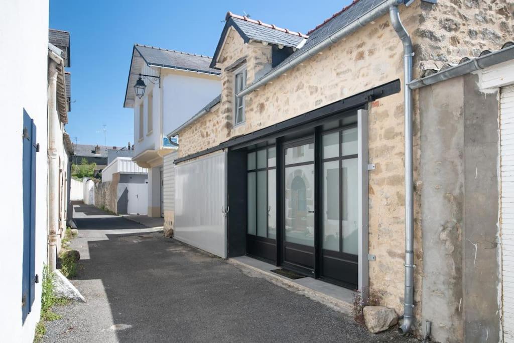 un bâtiment avec des portes en verre dans une rue dans l'établissement Maison de caractère hyper centre, au Pouliguen