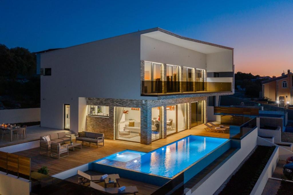 Bazén v ubytovaní Villa Ramarin 1 with heated pool, jacuzzi and sauna by the sea in Rogoznica alebo v jeho blízkosti