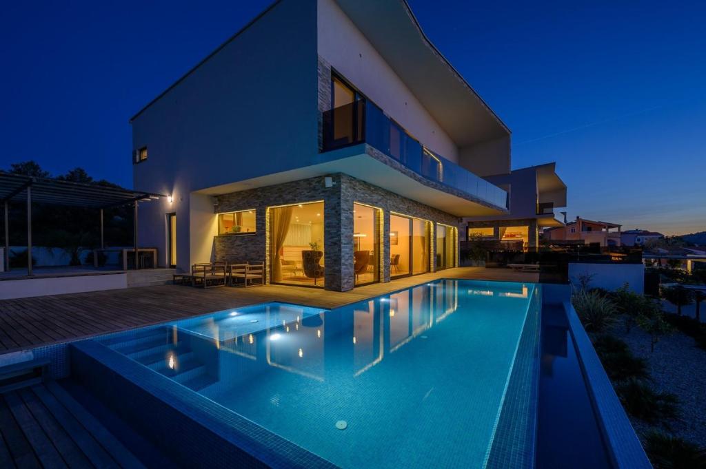 Bazén v ubytovaní Villa Ramarin 1 with heated pool, jacuzzi and sauna by the sea in Rogoznica alebo v jeho blízkosti