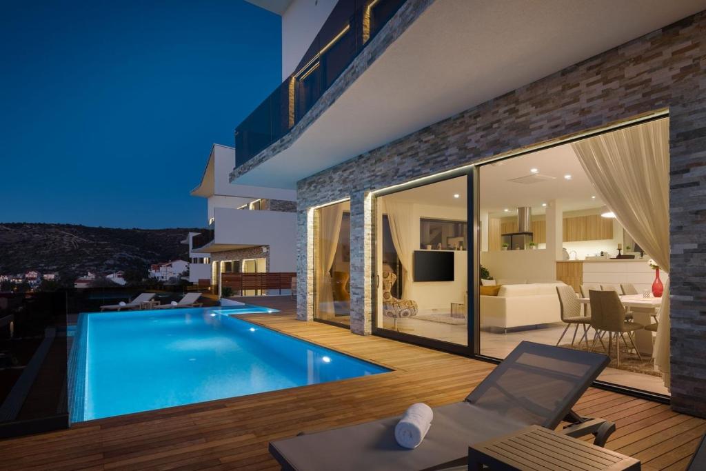 Bazén v ubytovaní Villa Ramarin 1 with heated pool, jacuzzi and sauna by the sea in Rogoznica alebo v jeho blízkosti